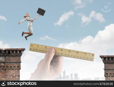 Risky business. Young businesswoman jumping over gap. Risk concept