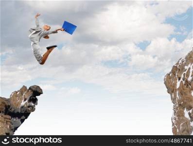 Risky business. Young businesswoman jumping over gap. Risk concept
