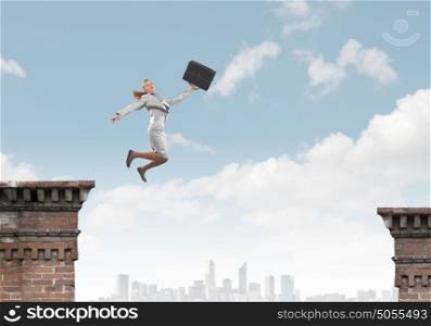 Risky business. Young businesswoman jumping over gap. Risk concept