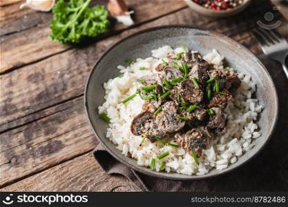 Risotto with mushrooms and herbs on an old wooden background. Rustic style.. Risotto with mushrooms