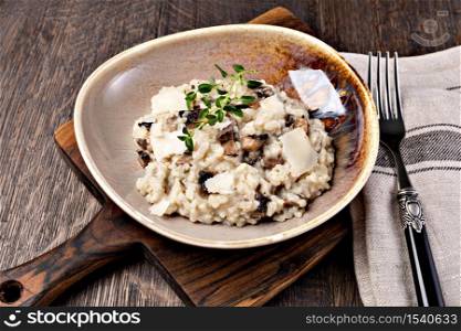 Risotto with porcini mushroom on wooden table. Mushroom risotto on plate, close up view