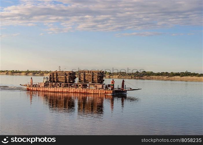 River ferry with timber on the Northern Dvina near Krasnoborsk, Russia. Sunset