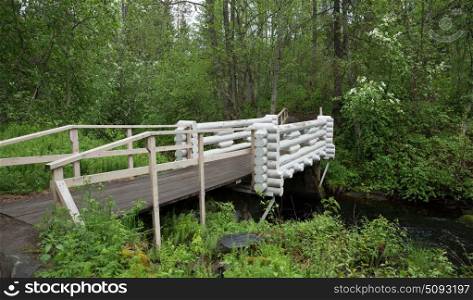 River flow and wooden bridge in the forest of Karelia