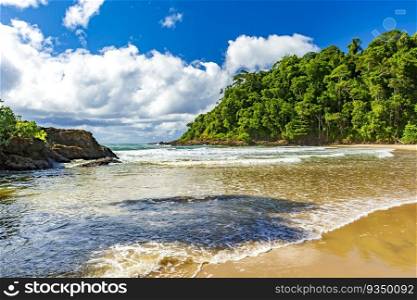 River flowing into the sea at the idyllic Ribeira beach surrounded by tropical forest in Itacare on the coast of Bahia. Paradisiacal Ribeira beach in Itacare, Bahia