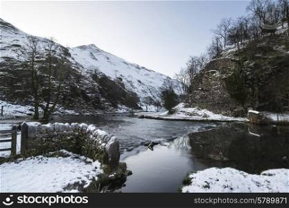 River flowing through snow covered Winter landscape in valley