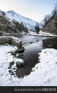 River flowing through snow covered Winter landscape in valley