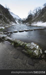 River flowing through snow covered Winter landscape in valley