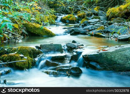 River flowing through stony bottom. Beautiful waterfall landscape. The water stream flowing over rocks. Beautiful mountain river landscape.. River flowing through stony bottom