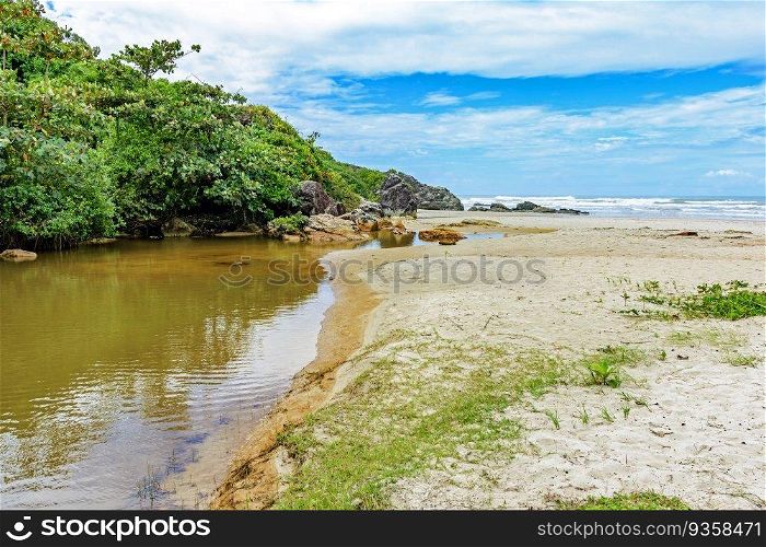 River going towards the sea with the sand, rocks and forest on the side in Serra Grande in Bahia. River going towards the sea on beach