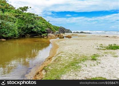 River going towards the sea with the sand, rocks and forest on the side in Serra Grande in Bahia. River going towards the sea on beach