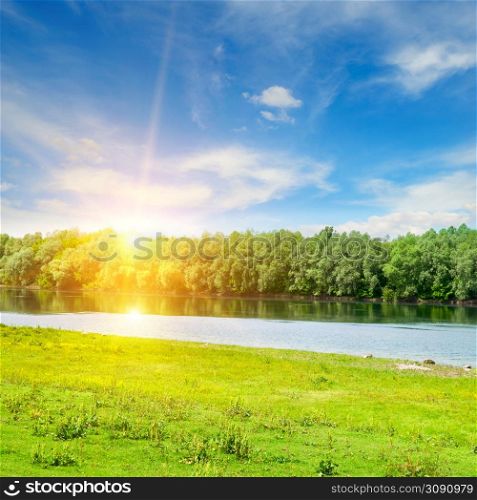 River, green meadow and forest on the shore. Summer morning with bright sun. Moldova.