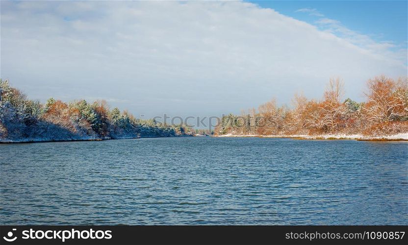 River landscape in winter and tree branches covered with white frost. Winter landscape on a sunny day.. River landscape in winter and tree branches covered with white frost.