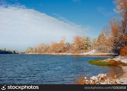 River landscape in winter and tree branches covered with white frost. Winter landscape on a sunny day.. River landscape in winter and tree branches covered with white frost.