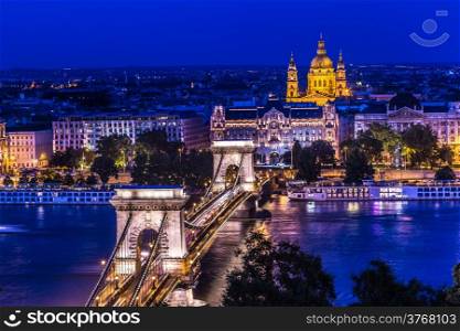River view of Budapest at evening, illuminated Chain Bridge and Parliament Building.