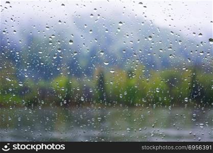 River view through window in rainy day. River view through window in rainy day. Rainy day. Rain drops. Rain drops background.