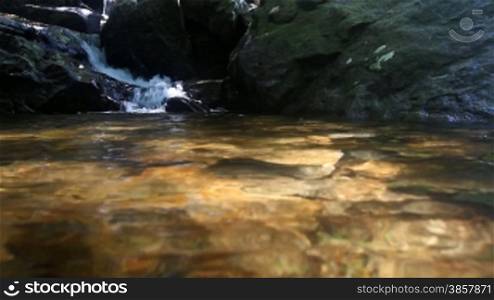 River water pouring into a pool surround by boulders