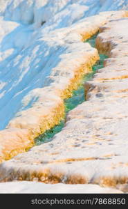 rivulet with turquoise water on the mountain in Pamukkale