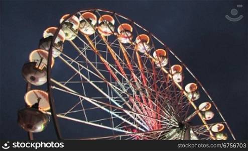 Rnckseite eines fahrenden, beleuchteten Riesenrads bei Nacht