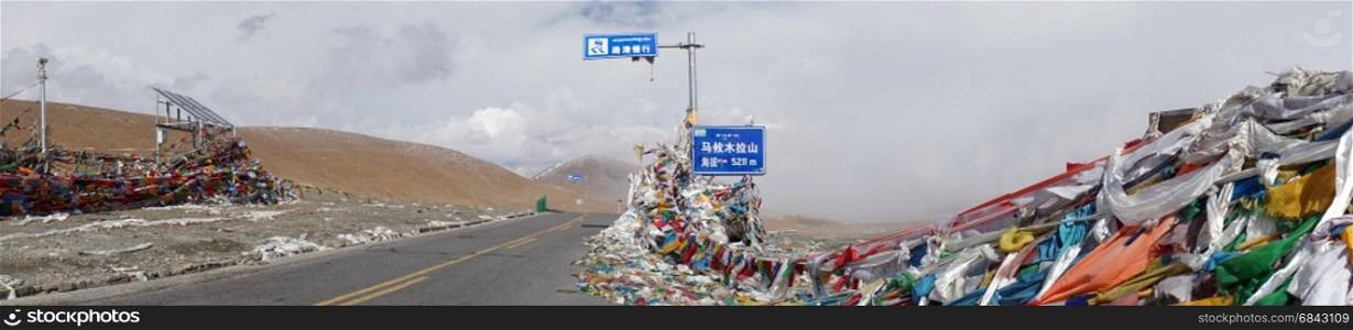 Road and flags on the Ma Yu La Pass in Tibet, China
