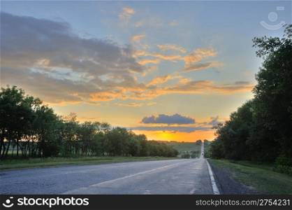 Road and sunset. An automobile line and a red sunset