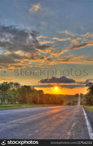 Road and sunset. An automobile line and a red sunset