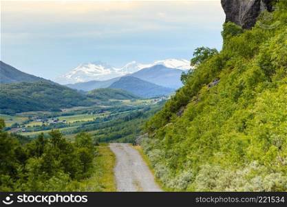 Road footpath running through summer green norwegian mountains. Beautiful landscape.. Pathway landscape in norwegian mountains