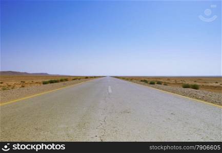 Road in a stone desert and blue sky - midle east