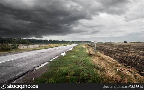 Road in cloudy weather against thunderclouds