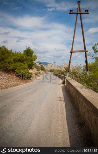 road in mountains and power line along it. road in mountains