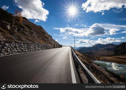 Road in the autumnal mountain. Fall colors alpine landscape sunny landscape