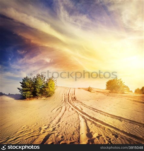 Road in the hot desert sand under a dramatic sky