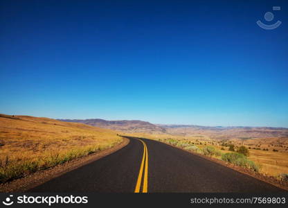 Road in the prairie country. Deserted natural travel background.