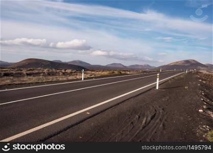 Road in volcanic landscape in Lanzarote, Canary islands, Spain.