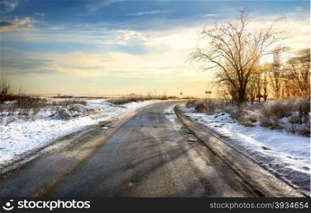 Road in winter at the beautiful sunset