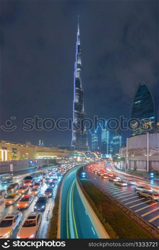 Road or street to Burj Khalifa in Dubai Downtown skyline and highway, United Arab Emirates or UAE. Financial district and business area in smart urban city. Skyscraper buildings at night.