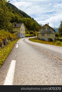 road passes alongside traditional Norwegian wooden houses, Norway