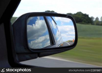 Road reflecting in the sideview mirror of a car