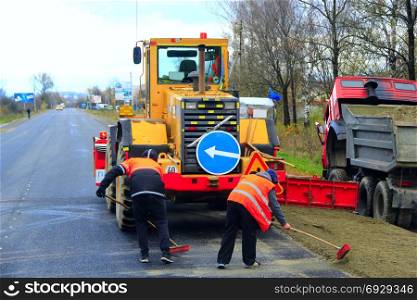 road-roller and repairmen make a repair of the road. road-roller and repairmen make a repair of the asphalted road