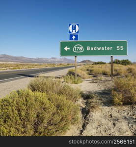 Road sign on side of desert road with direction to Badwater, Death Valley.