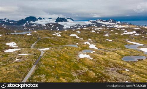 Road through mountain landscape. Snow peaks and glaciers in the distance. National tourist scenic route 55 Sognefjellet Norway. Aerial view. Mountains landscape. Norwegian route Sognefjellet