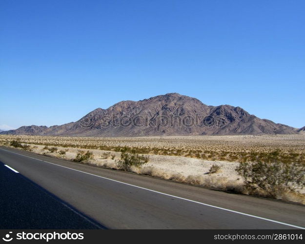 Road through the desert, view of the mountain