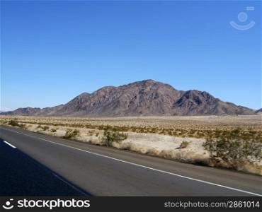 Road through the desert, view of the mountain