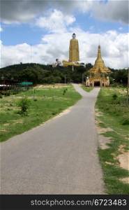 Road tj golden Buddhas and stupa near Mohnyin Thambuddhei Paya, Moniwa, Myanmar
