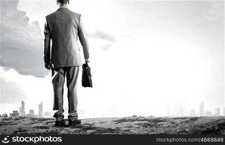 Road to success. Back view of businessman on road with suitcase in hand