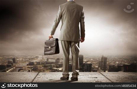 Road to success. Back view of businessman with suitcase in hand