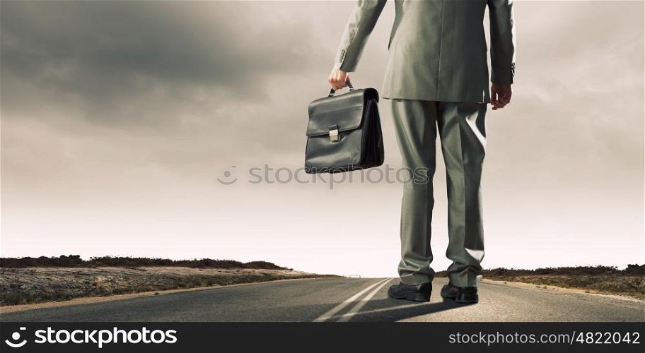 Road to success. Back view of businessman with suitcase in hand