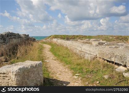 Road to the sea. A track among ruins of antique city