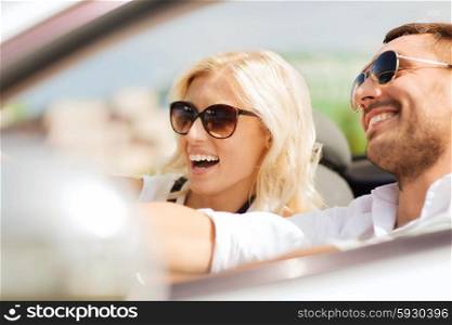 road trip, dating, leisure, couple and people concept - happy man and woman driving in cabriolet car outdoors