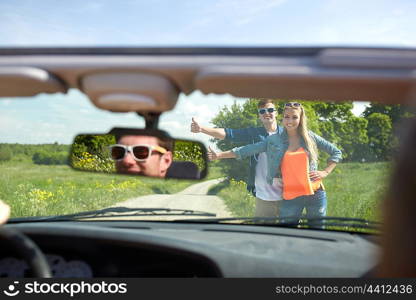 road trip, hitchhike, travel, gesture and people concept - happy couple hitchhiking and stopping car at countryside road