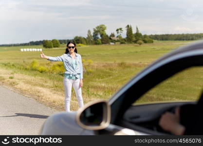road trip, hitchhike, travel, gesture and people concept - woman hitchhiking and stopping car with thumbs up gesture at countryside road